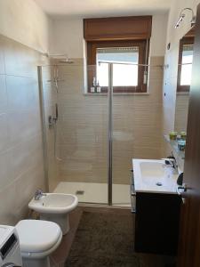 La salle de bains est pourvue d'une douche, de toilettes et d'un lavabo. dans l'établissement FIERA MILANO-RHO APARTMENT, à Pero