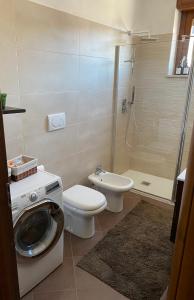 a bathroom with a washing machine and a toilet at FIERA MILANO-RHO APARTMENT in Pero