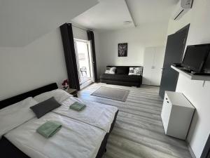 a bedroom with a bed and a living room at Laura Apartmanház in Mórahalom +24 photos