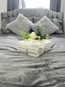uma cama com um cobertor branco e flores em Apartment in St Denys em Southampton