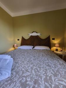 サン・クイーリコ・ドルチャにあるPalazzetto del Pittoreのベッドルーム1室(大型ベッド1台、ヘッドボード付)