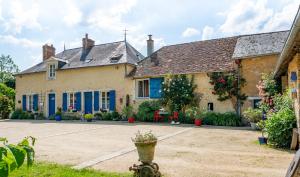 una casa con porte blu e un cortile di Chambres d'Hôtes Au Moulin 