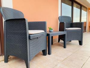 three wicker chairs and a table in a building at Villa Marogna in Alghero