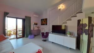 uma sala de estar com uma televisão e uma escada em Il Sogno Loft Indipendente em Crotone