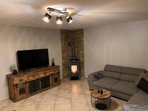 ein Wohnzimmer mit einem Sofa, einem TV und einem Kamin in der Unterkunft Ferienwohnung Körber in Gößweinstein