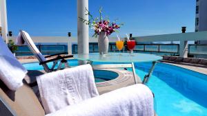 a table with two drinks on a balcony with a pool at Asia Paradise Hotel in Nha Trang