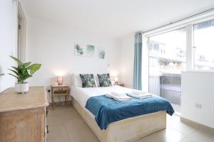 a bedroom with a bed and a large window at 2-bed 2-bath flat around the corner from Portobello Market in London