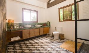 a bathroom with two sinks and a toilet at Villa Kulintang in Donsol