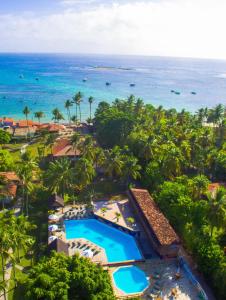 an aerial view of a resort with a swimming pool and the ocean at Village Paraíso Tropical in Morro de São Paulo