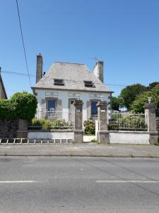 een wit huis met een hek en een straat bij Les Tilleuls in Plestin-les-Grèves