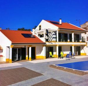 Casa blanca con techo rojo y piscina en 6 Persoons Woning met Zwembad. Rustig gelegen., en Figueira e Barros