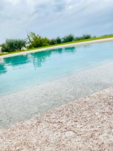 a swimming pool with blue water on a beach at B&B Villa Maggi in Locorotondo