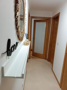 a hallway with a white counter and a mirror at Apartamento Mar de Arousa in Ribeira