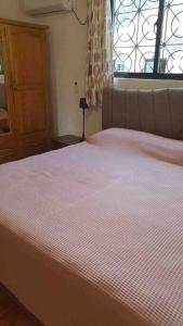 una camera da letto con un letto con copriletto rosa a righe di Riva D Etruschi Seychelles a Bel Ombre