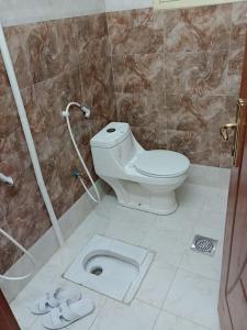a bathroom with a toilet and a shower stall with at 3 Bedroom Apartment in Mecca