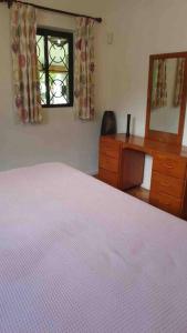 um quarto com uma cama, uma cómoda e uma janela em Riva D Etruschi Seychelles em Bel Ombre