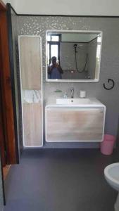 une personne prenant une photo d'une salle de bains avec lavabo dans l'établissement Riva D Etruschi Seychelles, à Bel Ombre
