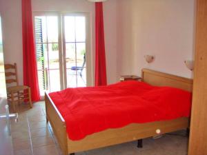1 dormitorio con 1 cama con colcha roja en 6 Persoons Woning met Zwembad. Rustig gelegen., en Figueira e Barros