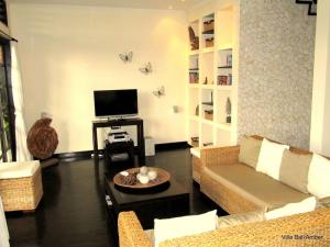 a living room with a couch and a tv at Bali Amber Villa in Banjar