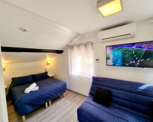 uma sala de estar com uma cama azul e um sofá em Hôtel restaurant et pension soirée étape Bel Air em Balaruc-les-Bains