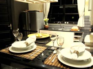 a kitchen with a table with plates and wine glasses at Bali Amber Villa in Banjar