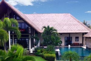 a house with a swimming pool in front of it at Bali Amber Villa in Banjar