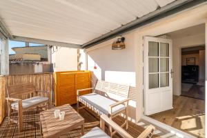 un porche con sillas, un banco y una mesa en Les Clés de Laure - Le 11 JACUZZI avec Terrasses Clim Netflix Parking, en Carcassonne