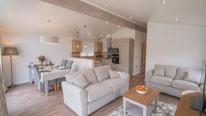 a living room with two couches and a dining room at Llyn Padarn Lodge in Betws-y-coed