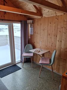 a room with two chairs and a table and a window at Hjallurin in Sandavágur