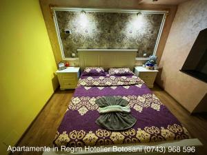 - une petite chambre avec un lit et une couverture violette dans l'établissement Apartament Ultra Modern 2 camere mari +1 camera mai mica, à Botoşani