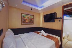 ein Hotelzimmer mit einem Bett und einem TV in der Unterkunft Sari Gili Bungalow in Gili Air