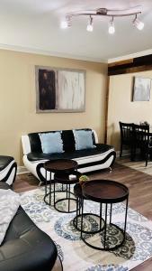 Trinity One Apartments - Industrial Luxury في جاكسون: غرفة معيشة مع أريكة وطاولتين