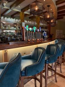 a bar with blue chairs and a bar counter at Moycarn Lodge & Marina in Ballinasloe