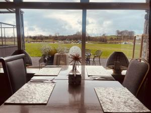 a dining room with a table and a large window at Moycarn Lodge & Marina in Ballinasloe