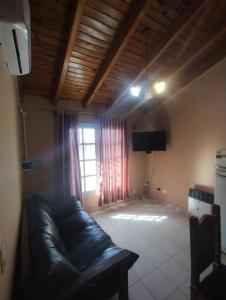 - un salon avec un canapé en cuir et une télévision dans l'établissement Casa Román Martínez, à San Rafael