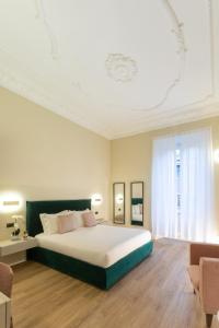 a bedroom with a large bed and a large window at Elegantia Luxury Rooms in Rome