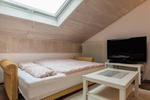 1 dormitorio con 1 cama, TV y mesa en Modernes Apartment zum Wohlfühlen, en Kolbermoor