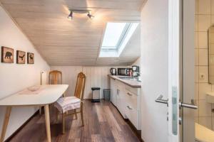 une petite cuisine avec une table et une fenêtre dans l'établissement Modernes Apartment zum Wohlfühlen, à Kolbermoor