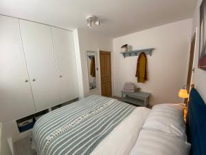 a small bedroom with a bed and white cabinets at Little Trevio - seaside haven with parking and sea views in Brixham