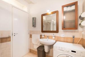 a bathroom with a sink and a toilet and a mirror at Ca' Del Jago Sole Luna apartment in Negrar
