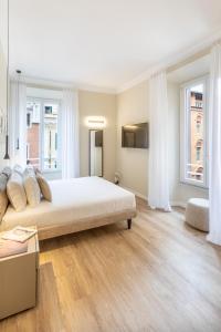 ein Schlafzimmer mit einem großen Bett und zwei Fenstern in der Unterkunft Elegantia Luxury Rooms in Rom
