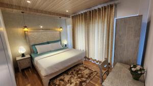 - une chambre avec un lit, une fenêtre et une table dans l'établissement Knightsbridge Grand Apartment, à Nuwara Eliya