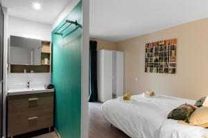 a bedroom with a bed and a bathroom with a sink at Appartement Aloa in Carcassonne