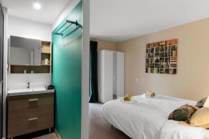 Un dormitorio con una cama y un baño con lavabo. en Appartement Aloa, en Carcassonne