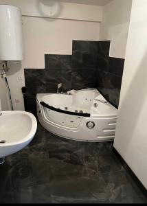 ein Badezimmer mit einer weißen Badewanne und einem Waschbecken in der Unterkunft FeWo Teusch Top 6 in Arnoldstein