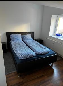 ein Bett mit blauer Bettwäsche und Kissen in einem Schlafzimmer in der Unterkunft FeWo Teusch Top 6 in Arnoldstein