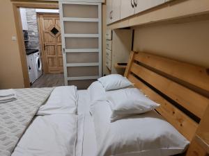 two beds in a small bedroom with a closet at Damjanich apartman in Kaposvár