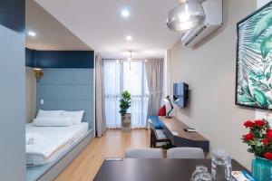 een hotelkamer met een bed, een bureau en een tafel bij The Peony Apartment in Ho Chi Minh-stad