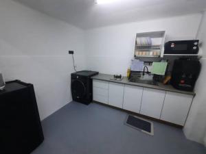 a kitchen with a counter with a sink and a microwave at XHQ Home Stay - BayView B-9-1 in Kampong Baharu