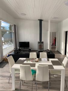 Kemping في Föglö: غرفة معيشة مع طاولة وكراسي بيضاء